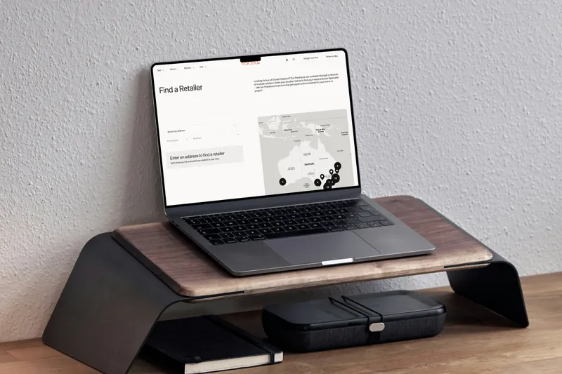The Escea website on a laptop on a walnut stand