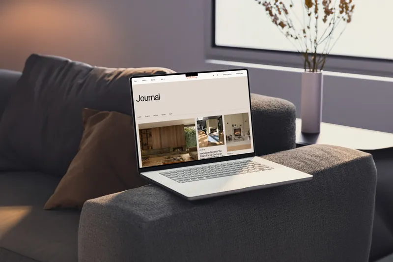 The Escea website on a laptop on a grey couch